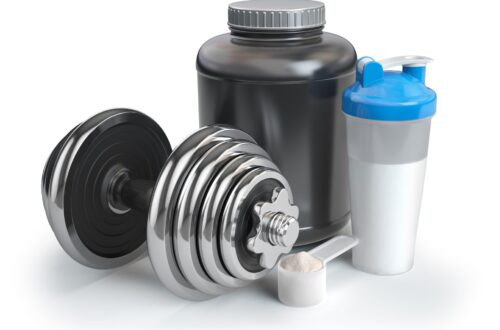 Poudre de protéine de lactosérum en cuillère avec shaker et haltère. Concept nutritionnel Bodybuilder.
