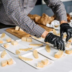 Traiteur préparant des plateaux de fromages pour un événement.