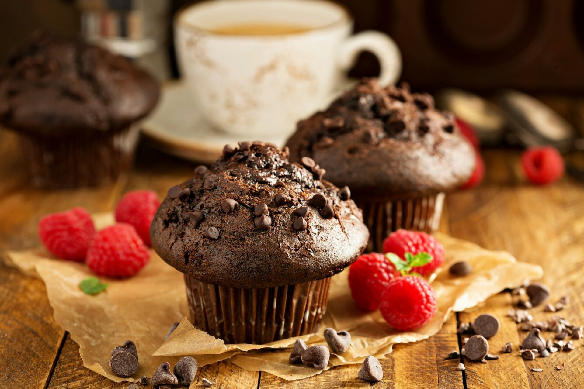 Muffins double chocolat à la framboise et une tasse de café dans un cadre rustique