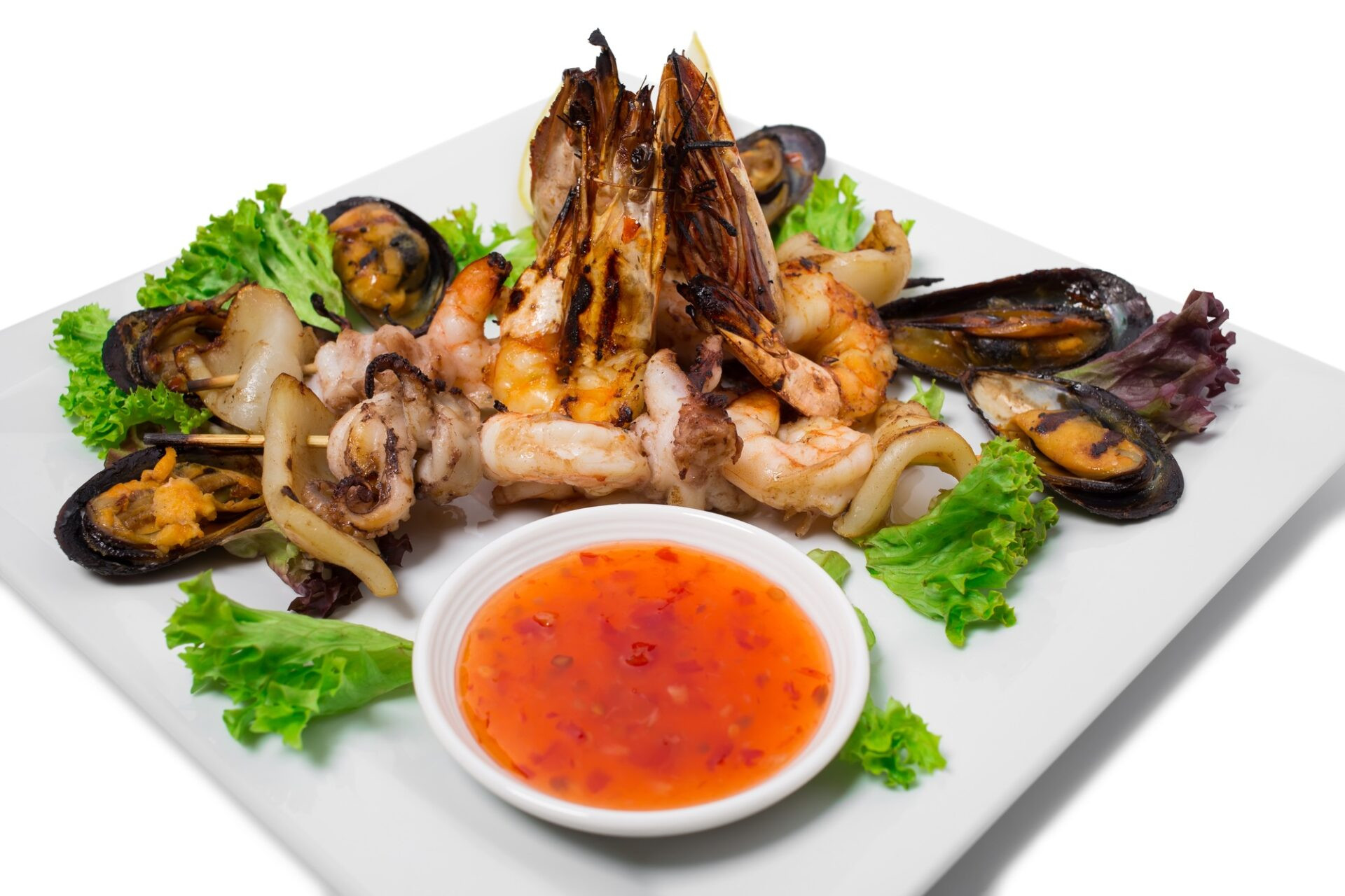 Délicieux plateau de fruits de mer grillés avec sauce piquante. 