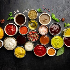 Ensemble de différents bols de diverses sauces de trempette, sur fond sombre, vue de dessus