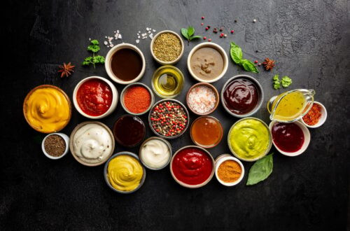 Ensemble de différents bols de diverses sauces de trempette, sur fond sombre, vue de dessus