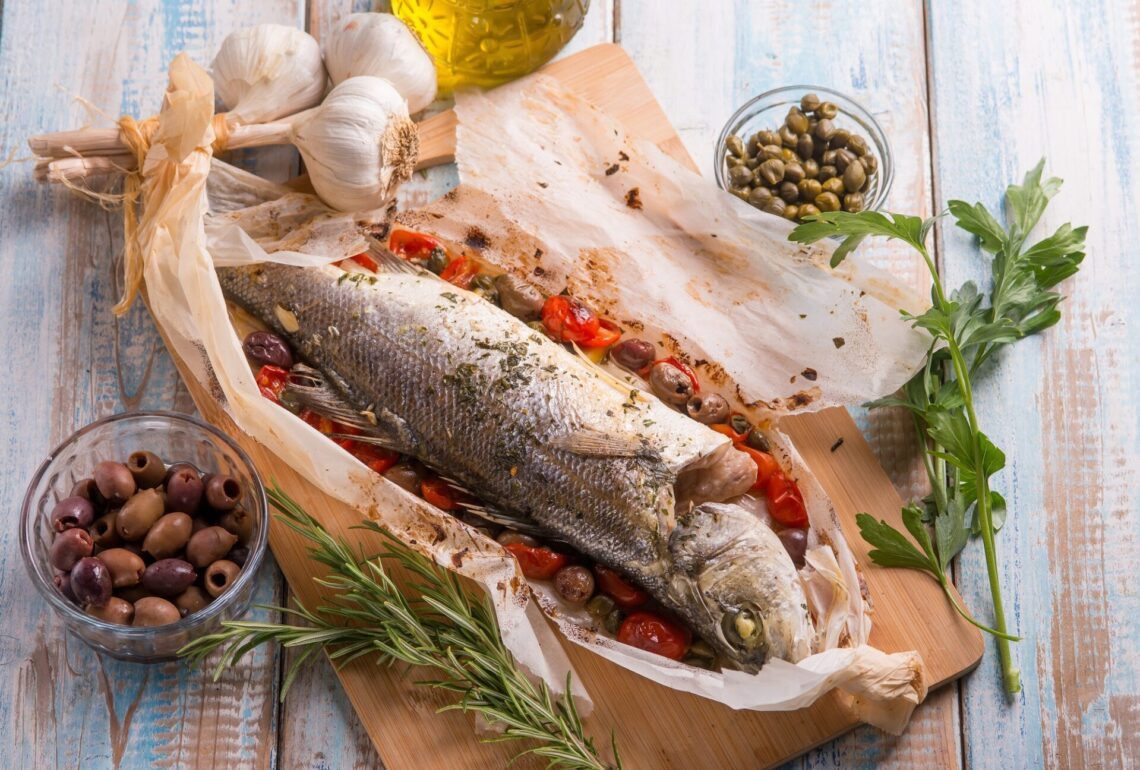 Basse de mer en feuille avec des olives noires tomates Adn Capers