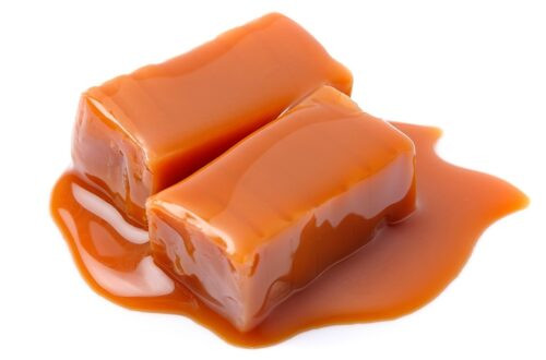 Des bonbons au caramel et une garniture au caramel isolé sur fond blanc.