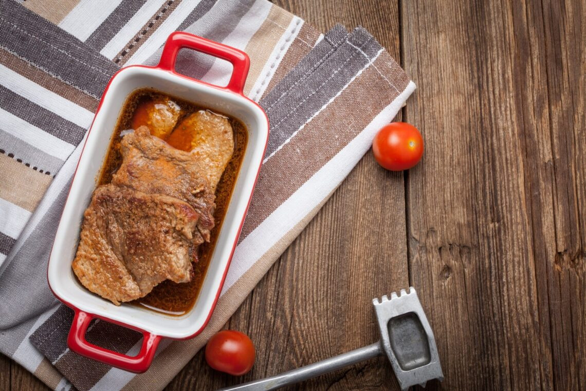 Porc braisé dans la sauce sur une table en bois.