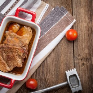 Porc braisé dans la sauce sur une table en bois.